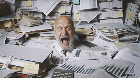 Stressed Businessman Buried Under A Lot Of Paperwork Stock Photo