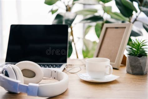 Closeup View Of Headphones Laptop With Blank Screen Coffee Cup