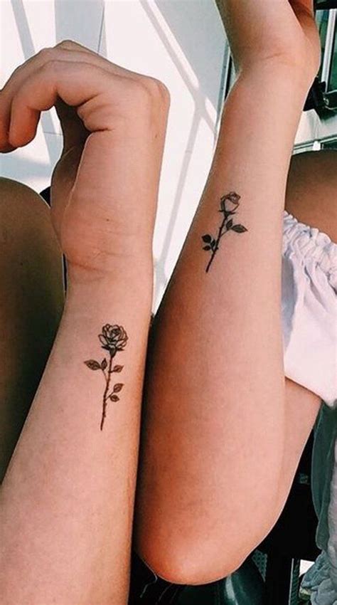 two women with matching tattoos on their arms one has a rose and the other has a flower