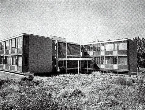 An Old Black And White Photo Of Two Buildings On The Side Of A Hill