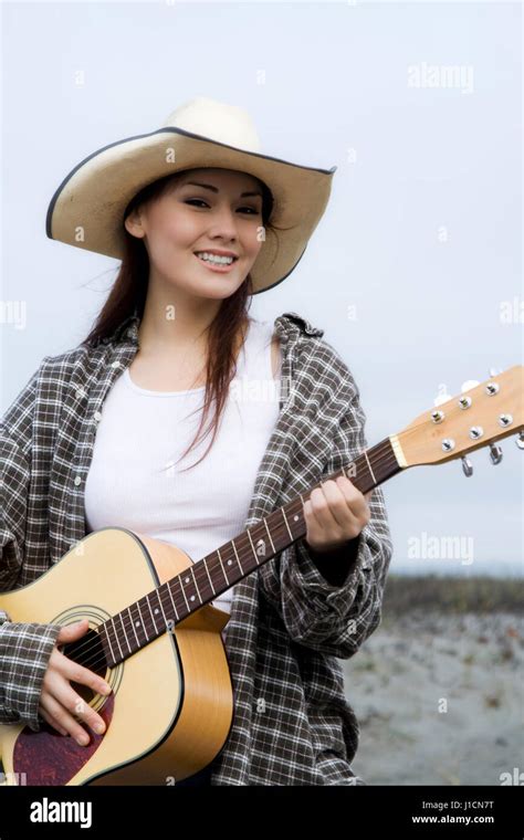A Portrait Of A Beautiful Young Woman Playing Guitar Outdoor Stock