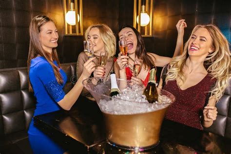 Women Clinking Champagne Glasses And Celebrating At Night Club Stock