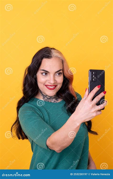 portrait of an attractive woman making a selfie over yellow background stock image image of