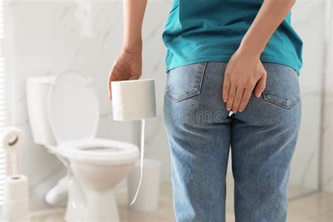 Boy With Paper Suffering From Hemorrhoid On Toilet Bowl In Rest Room