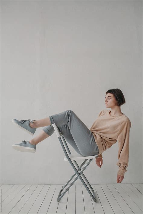stylish woman sitting on the white chair by stocksy contributor sergey filimonov 여성 포즈 참조