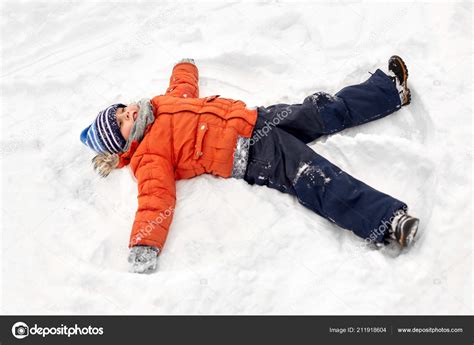 Happy Little Boy Making Snow Angels In Winter — Stock Photo © Syda