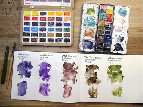 Some Watercolors Are Sitting On A Table Next To An Artists Palette