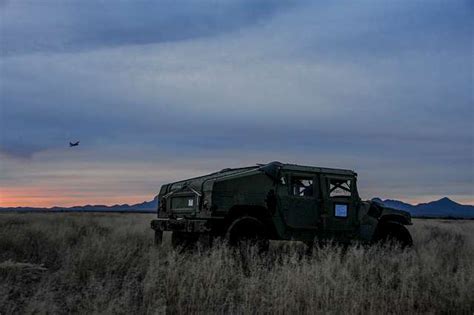 A Humvee Sits In A Field While The Us Air Force Hc 130j Nara