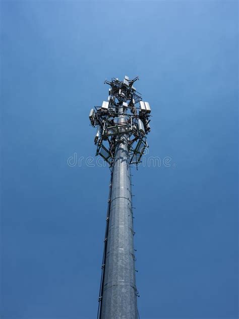 Tall Cell Phone Antenna Tower Next To Small Building Situated On Top Of
