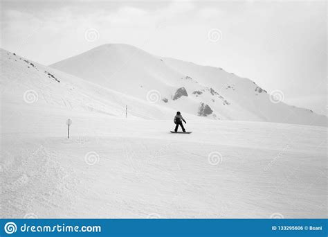 Snowboarder Downhill On Snowy Ski Slope And Mountains In Fog Stock