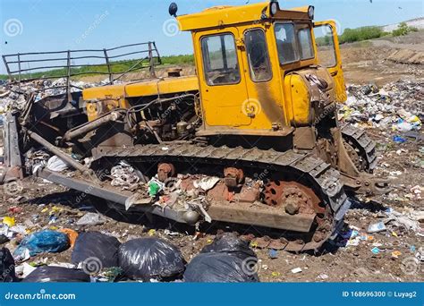 A Bulldozer Clears Heaps Of Garbage In A Garbage Can Work Bulldozer In