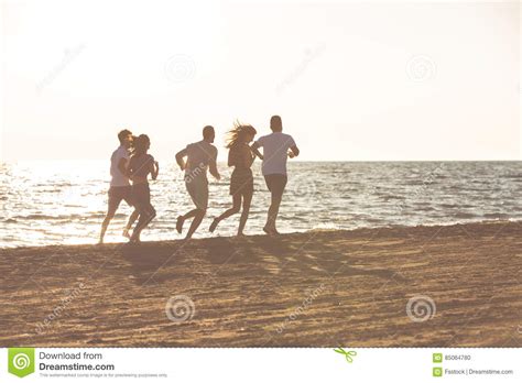 Happy Young People Group Have Fun White Running And Jumping On Beach At