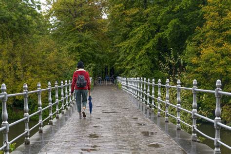 Metal Railing Bridge After A Rainy Day And Woman Cross The Bridge With