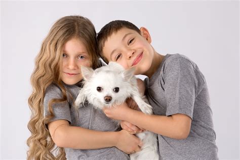 A Boy And A Girl Are Holding A White Chihuahua Wallpapers
