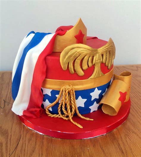 Woman is drawing chocolate on top of birthday butter cake decoration. Delectable Cakes: Wonder Woman with Cape Birthday Cake