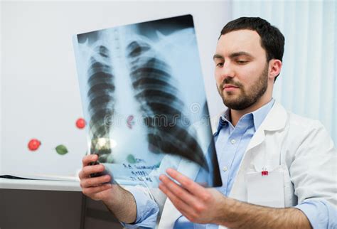 Close Up Portrait Of Doctor Looking At Chest X Ray In His Office Stock
