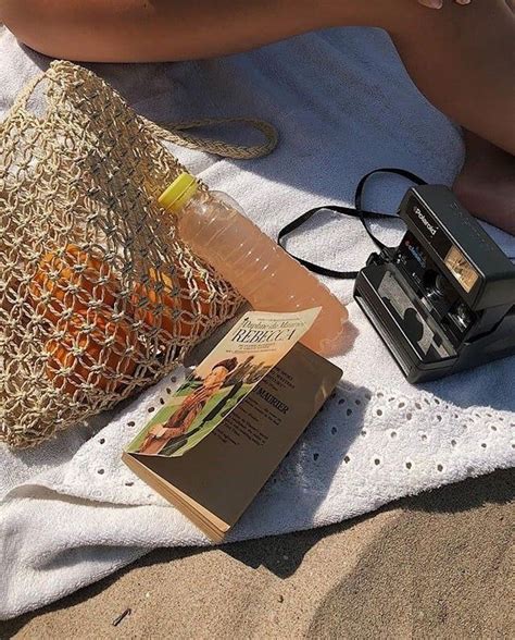 An Old Camera Book And Sunglasses On A Towel Next To A Bottle Of Water