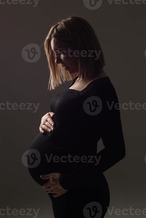 Stylish Beautiful Pregnant Woman In A Black Dress Holds Her Hands On Her Stomach 6673531 Stock
