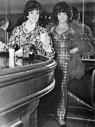 Two Women Standing Next To Each Other At A Bar