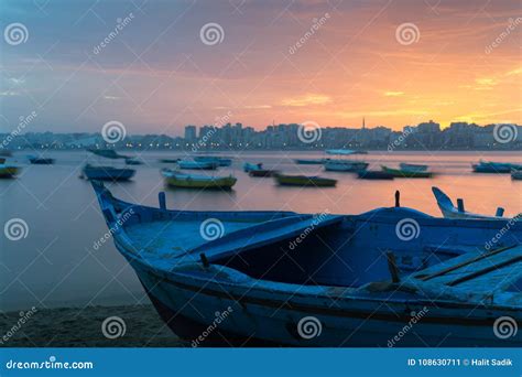 Turquoise Blue Fishing Boat On The Beach At Sunrise With Alexandria