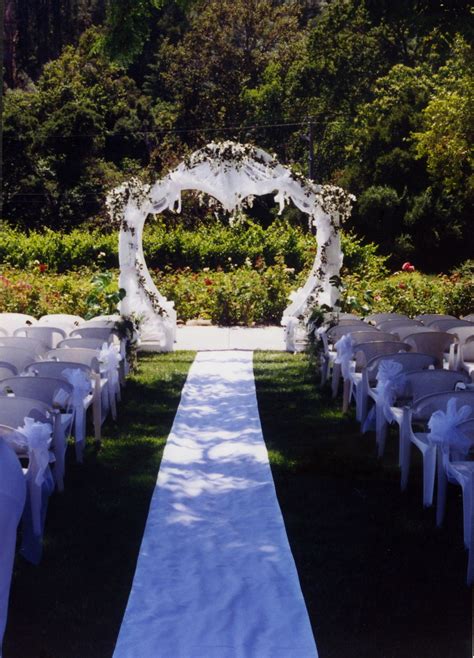 Heart Shaped Arch Decorated In White Tulle Silk Wisteria Plants And