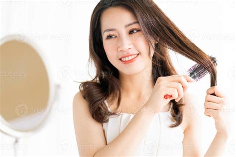 Woman Sitting Brushing Her Hair With A Happy Expression 2870895 Stock