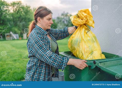 European 30s Woman Throwing Garbage Into The Recycling Bin In The