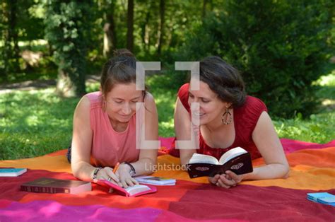 Women Reading Bibles On A Blanket In The Grass — Photo — Lightstock