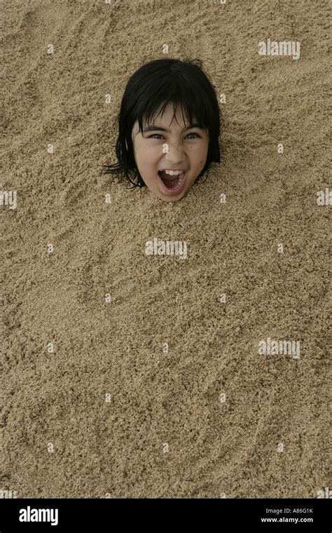 View Of A Girl Buried In Sand Stock Photo Alamy