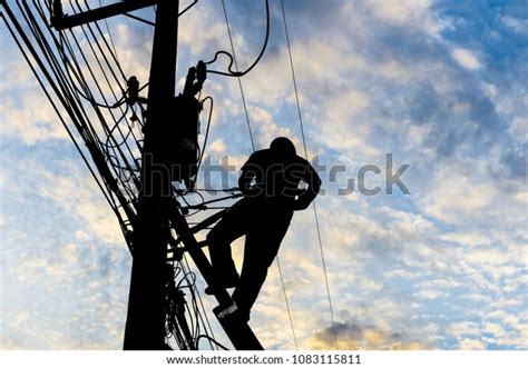 Silhouetted Electricians Working Electric Pole Blue Stock Photo Edit