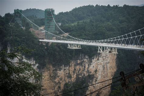 Zhangjiajie grand canyon glass footbridge 张家界大峡谷玻璃桥 world's highest footbridge sanguansixiang, hunan, china 853 feet high / 260 meters high 1,411 foot span / 430 meter span 2016. China is home to world's highest and longest glass ...