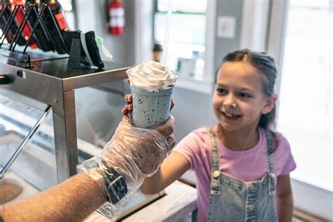 Young Girl Handed A Milkshake By Stocksy Contributor Sean Locke