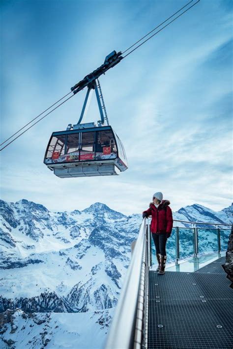 A Person Walking Down A Walkway With A Ski Lift In The Air Above Them