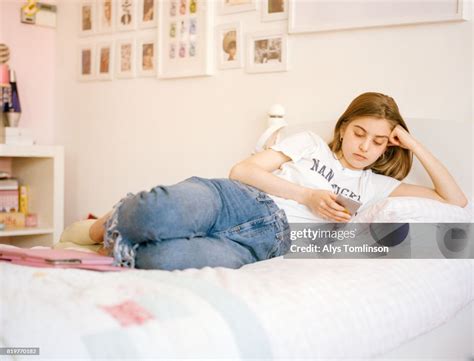 Teenage Girl Lying On Bed Using Mobile Phone Bildbanksbilder Getty Images