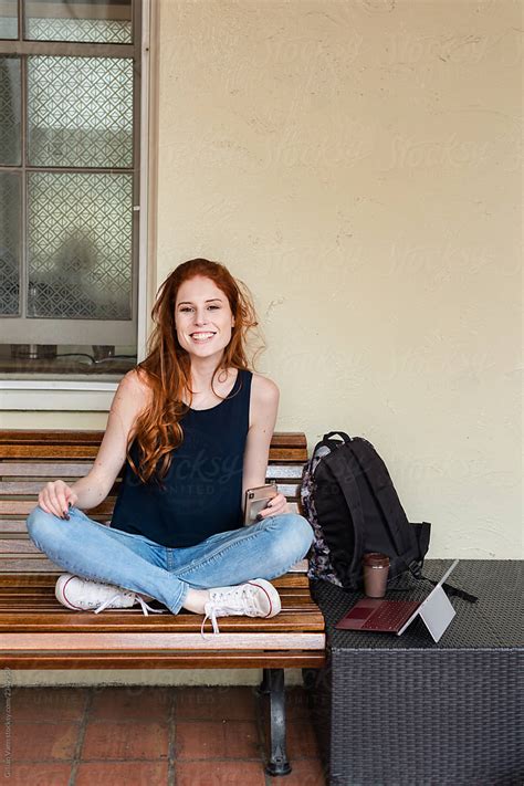 redhead woman sitting on bench by stocksy contributor gillian vann stocksy