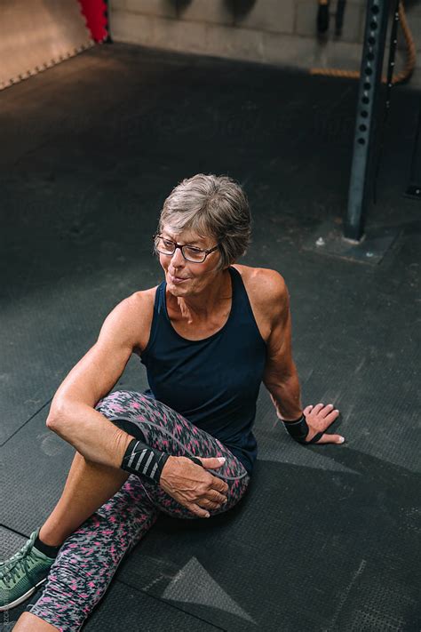 senior woman stretching at gym by stocksy contributor rzcreative stocksy