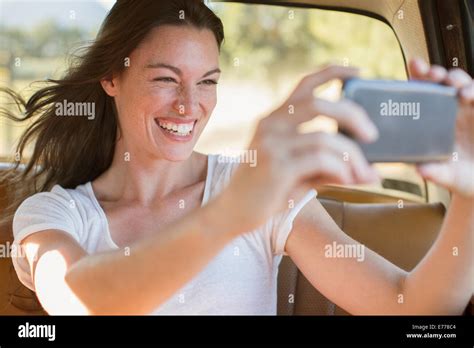 Woman Riding In Car Taking Picture With Cell Phone Stock Photo Alamy