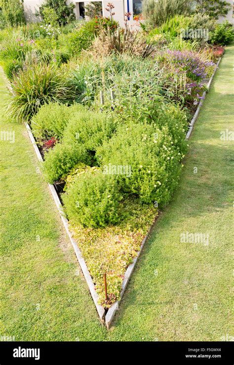 Triangular Raised Flower Bed On Large Garden Lawn Stock Photo Alamy