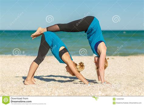 Two Womans Doing Yoga Fitness Exercises On The Sea Beach Editorial