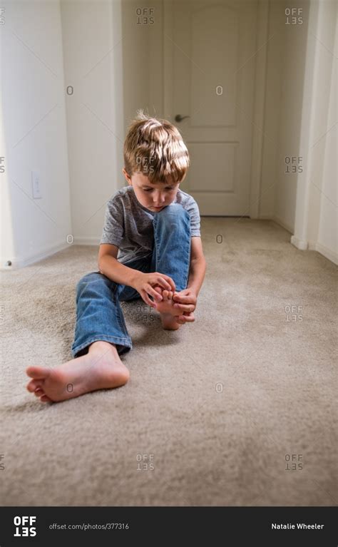 Boy Holding His Foot In Home Stock Photo Offset
