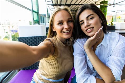 Two Smiling Women Friends Driniking Coffee And Taking Selfie