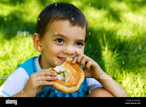 Little Boy Eating A Sweet Bun On Nature Stock Photo Alamy