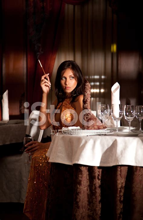Attractive Alone Woman Smoking Cigarette At Restaurant Stock Photo