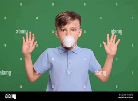 Surprised Boy Blowing Bubble Gum On Green Background Stock Photo Alamy