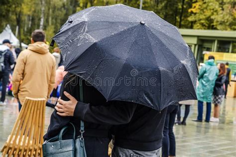 People Walk Under An Umbrella In Rainy Weather A Young Couple Hidden