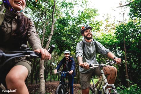 Group Of Friends Ride Mountain Bike In The Forest Together Premium