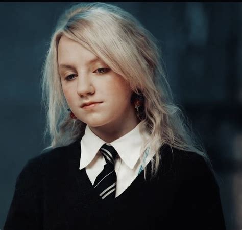 A Woman With Blonde Hair Wearing A Black And White Striped Tie Looking Off To The Side