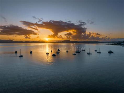 Aerial Sunrise Waterscape With Boats Clouds And Sun Rays Stock Photo