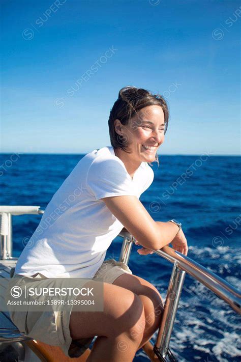 Caucasian Woman Sitting On Boat Deck Superstock