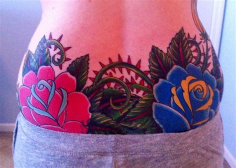 Large Red And Blue Roses On Either Side Of Spine With Black Lace And Thorns On Lower Back Tat
